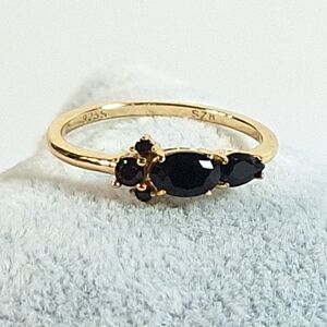 Elegant Gold and Black Ring with Gemstone Trio